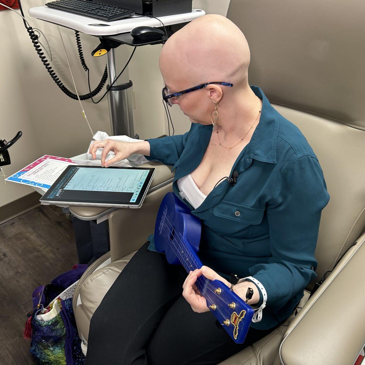 Gillian Hollis plays a guitar while receiving treatment.jpg